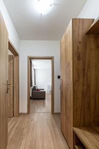 a hallway with wooden doors and a living room at Apartmán Janka in Liptovský Ján