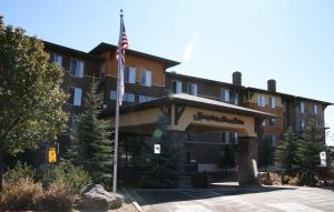 um hotel com uma bandeira americana em frente em Hampton Inn & Suites Flagstaff - West em Flagstaff