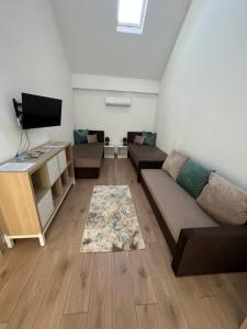 a living room with a couch and a tv at Pap köz apartman in Sárvár