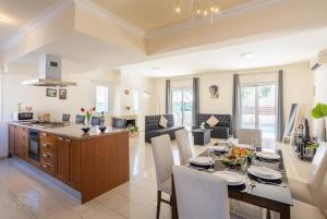 een keuken en een woonkamer met een tafel en stoelen bij Villa Miracle in Paralimni