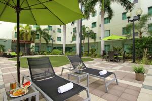 a patio with two chairs and an umbrella at Homewood Suites by Hilton Fort Lauderdale Airport-Cruise Port in Dania Beach