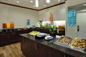Una gran cocina con una barra con comida. en Homewood Suites by Hilton Fort Lauderdale Airport-Cruise Port, en Dania Beach