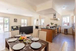 uma cozinha e sala de jantar com mesa e cadeiras em Villa Miranda em Paralimni