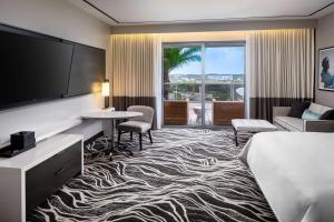 a hotel room with a bed and a flat screen tv at Hilton Miami Aventura in Aventura