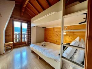 een slaapkamer met een stapelbed en een houten muur bij Chalet Baudelaire, 4* beau et authentique in Xonrupt-Longemer