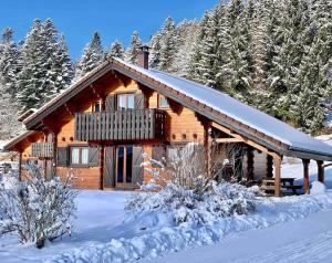 ein Blockhaus mit einer Terrasse im Schnee in der Unterkunft Chalet Baudelaire, 4* beau et authentique in Xonrupt-Longemer