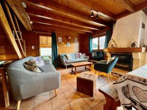 ein Wohnzimmer mit einem Sofa und einem Kamin in der Unterkunft Chalet Baudelaire, 4* beau et authentique in Xonrupt-Longemer