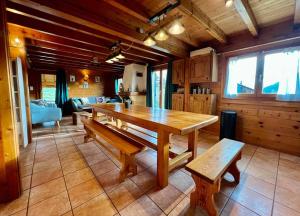 ein Esszimmer mit einem Holztisch und Bänken in der Unterkunft Chalet Baudelaire, 4* beau et authentique in Xonrupt-Longemer