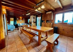 a dining room with a wooden table and benches at Chalet Baudelaire, 4* beau et authentique in Xonrupt-Longemer