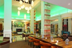 een restaurant met tafels en stoelen en een open haard bij Hilton Garden Inn Ft. Lauderdale Airport-Cruise Port in Dania Beach