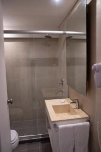 uma casa de banho com um lavatório, um chuveiro e um WC. em Urbana Class Hotel em Mendoza