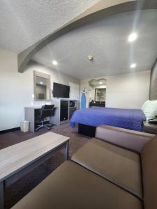 ein Hotelzimmer mit einem Bett und einem Schreibtisch in der Unterkunft Scottish Inn and Suites Beaumont in Beaumont
