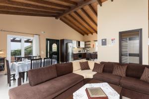 a living room with a couch and a table and a kitchen at Villa Konstantinos in Katávolos