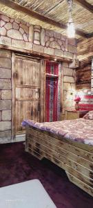 Dormitorio en cabaña de madera con cama grande en My Grandfather's House en Ḑānā