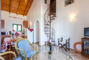 a dining room with a glass table and a spiral staircase at Villa Martha in Ieromónachos