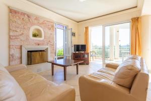 a living room with a couch and a fireplace at Villa Asimenia in Agia Triada