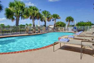una piscina con tumbonas y palmeras en Hampton Inn & Suites Ft. Lauderdale/West-Sawgrass/Tamarac, FL en Tamarac