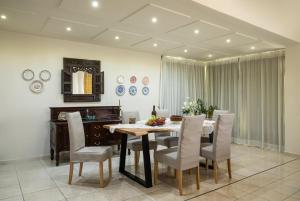 a dining room with a table and chairs and a mirror at Villa Armi in Episkopi