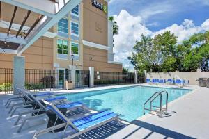 a swimming pool with lounge chairs and a hotel at Home2 Suites by Hilton Miramar Ft. Lauderdale in Miramar