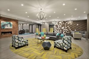 a lobby with couches and chairs and a fireplace at Homewood Suites By Hilton Florence in Florence