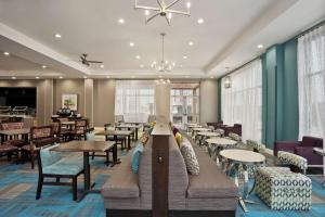 a restaurant with couches and tables and chairs at Homewood Suites By Hilton Florence in Florence