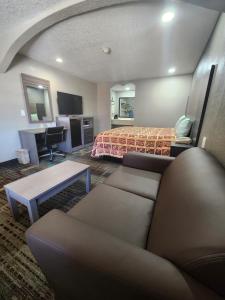 a hotel room with a couch and a bed at Scottish Inn and Suites Beaumont in Beaumont
