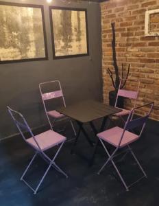 einen Tisch und 4 Stühle in einem Zimmer mit Ziegelwand in der Unterkunft En Remolinos in Cruz del Eje