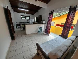 a living room with a bed and a kitchen at Mandala casa 3 dorms cond fech piscina churrasqueira in Boicucanga