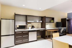 a kitchen with black and white appliances and a table at Home2 Suites by Hilton Sioux Falls Sanford Medical Center in Sioux Falls