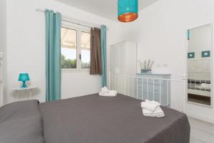 ein Schlafzimmer mit einem Bett mit zwei Handtüchern darauf in der Unterkunft Villino Malva in Ragusa