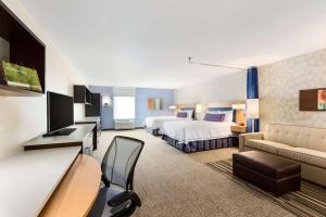 スーフォールズにあるHome2 Suites by Hilton Sioux Falls Sanford Medical Centerのベッド2台とソファが備わるホテルルームです。