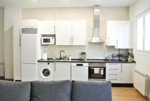 a kitchen with white appliances and a couch at Loft coqueto en Madrid a 2 minutos del metro in Madrid