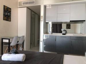 een keuken met witte kasten en een tafel bij Black Sea Vi Dari Apartments in Batoemi +169 foto's