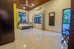 a bedroom with a bed in the middle of a room at Spacious 4BR 4BA Family Villa wt Balcony & Lavish Garden in Ratmalana