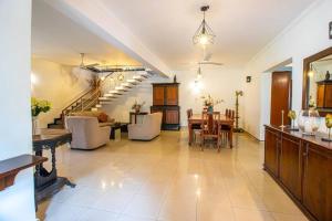 a large living room with a table and a staircase at Spacious 4BR 4BA Family Villa wt Balcony & Lavish Garden in Ratmalana