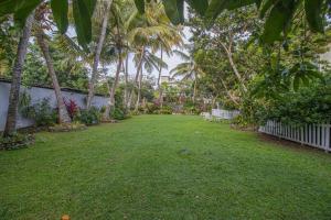 a yard with palm trees and a white fence at Spacious 4BR 4BA Family Villa wt Balcony & Lavish Garden in Ratmalana