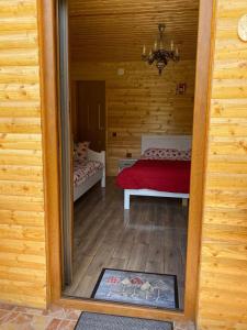 a room with a bed in a wooden house at CAMPING THOBIAS in Alunu