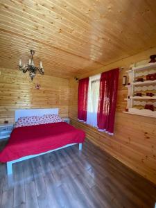 a bedroom with a bed in a wooden cabin at CAMPING THOBIAS in Alunu