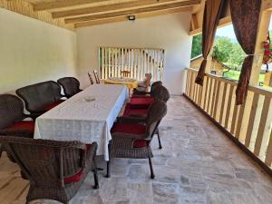a dining room with a white table and chairs at CAMPING THOBIAS in Boşorod