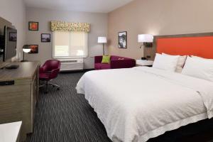 een hotelkamer met een groot bed en een bureau bij Hampton Inn Fort Stockton in Fort Stockton