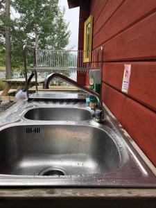 eine Küchenspüle mit einem Wasserhahn darüber in der Unterkunft Stuga med sjöläge in Kopparberg