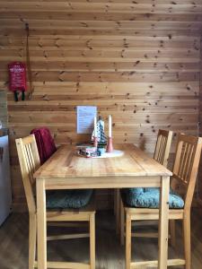 een houten tafel met 2 stoelen en een houten muur bij Stuga med sjöläge in Kopparberg