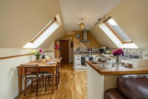 una cocina con mesa y una cocina con tragaluces. en The Barn at Dormouse Cottage en Selkirk