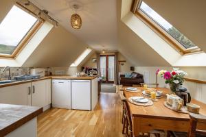 cocina y sala de estar con mesa de madera en The Barn at Dormouse Cottage en Selkirk