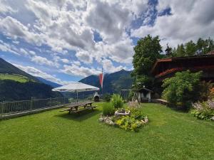 stół piknikowy z parasolką na trawniku w obiekcie Nature luxury Chalet INSToul w mieście Lutago