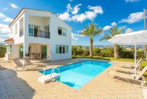 een villa met een zwembad en een huis bij Villa Iliada in Polis Chrysochous