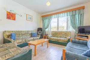 sala de estar con sofás, TV y mesa en Villa Iliada, en Polis Chrysochous