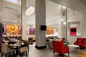 une salle à manger avec des tables et des chaises ainsi qu'un restaurant dans l'établissement Hilton Fort Wayne at the Grand Wayne Convention Center, à Fort Wayne