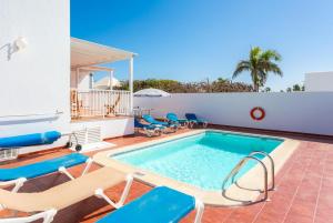 a swimming pool with chaise lounge chairs and a swimming pool at Villa Tania in Puerto del Carmen