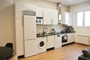 a kitchen with white cabinets and a washer and dryer at Loft coqueto en Madrid a 2 minutos del metro in Madrid